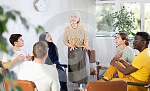 Senior female psychotherapist leading group therapy session