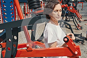 Senior female training upper body on sports ground