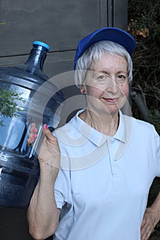 Senior female worker delivering purified water tank