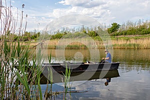 Senior fisherman in a boat at Danube-Tisa-Danube channel near Novi Sad, Serbia