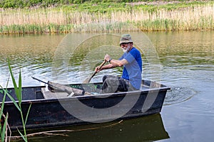 Senior fisherman in a boat at Danube-Tisa-Danube channel near Novi Sad, Serbia