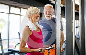 Senior fit man and woman doing exercises in gym to stay healthy