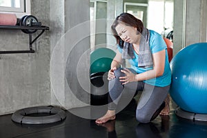 Senior fitness woman injury knee pain while exercising in gym. aged lady suffering from Arthritis . Old female workout .Mature