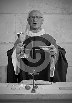 A Senior French Catholic priest is giving mass during a baptism in Aquitaine