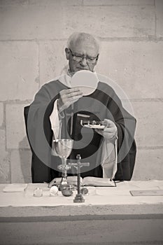 A Senior French Catholic priest is giving mass during a baptism in Aquitaine