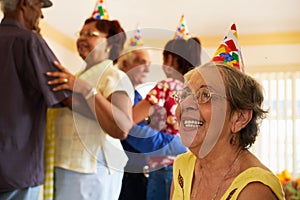 Senior Friends Dancing At Birthday Party In Hospice