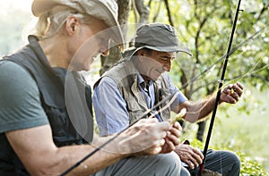 Senior friends fishing by the lake