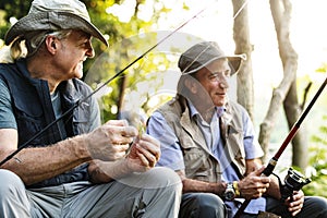 Senior friends fishing by the lake