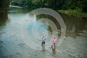 Senior friends fishing by the lake. Handsome man relaxing. Family day. United with nature. Hobby and sport activity