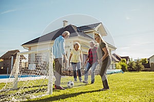 Senior friends having fun playing football in the backyard