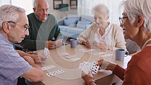 Senior friends playing cards together at nursing home