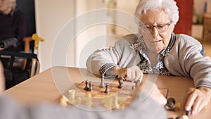 Senior friends playing chess in a nursing home