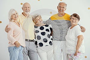 senior friends standing together and smiling