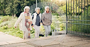 Senior friends, walking and talking together on an outdoor path to relax in nature with elderly women in retirement