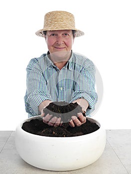 Senior gardener with fistful of soil