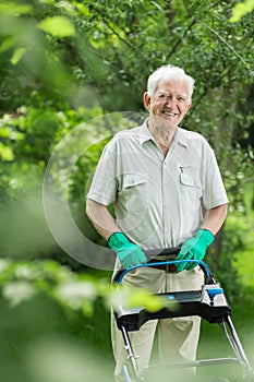 Senior gardener mowing the grass