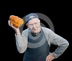 Senior gardener with a pumpkin. The 87 - year-old farmer enjoys the pumpkin harvest in the garden. Cheerful active old man by