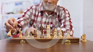 Senior gentleman training for chess competition, developing strategy, checkmate