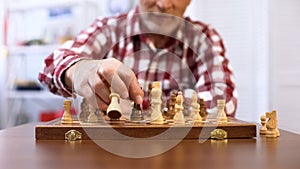 Senior gentleman training for chess competition, developing strategy, checkmate