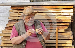 Senior getting ready to drink two raw hens egg while sitting outdoor