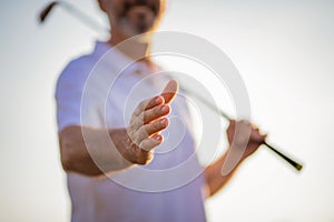 Senior golfer spreading his hand. Close up.