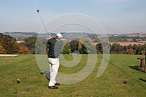 Senior golfer teeing off in autumn