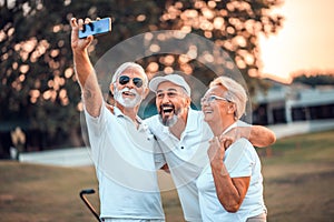 Senior golfers using phone and taking self portrait