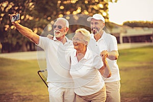 Senior golfers using phone and taking self portrait