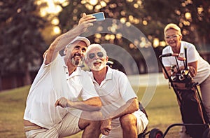 Senior golfers using phone and taking self portrait