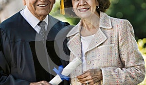 Senior Graduate holding diploma with his Wife
