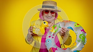 Senior grandmother traveler tourist with swimming ring ready for vacation, journey trip to seaside