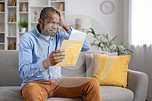 Senior gray haired man upset received envelope mail message notification with bad news, sad displeased and disagreeable