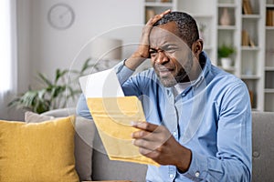 Senior gray haired man upset received envelope mail message notification with bad news, sad displeased and disagreeable