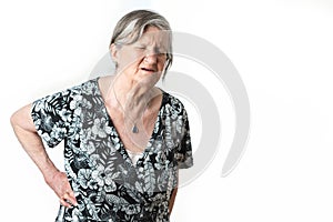 Senior gray-haired woman suffering back pain on isolated white background