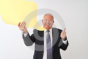 Senior grey-haired businessman holding speech bubble over isolated white background happy with big smile doing ok sign, thumb up