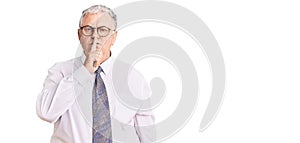 Senior grey-haired man wearing business clothes asking to be quiet with finger on lips