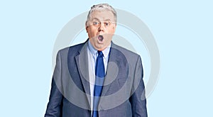 Senior grey-haired man wearing business jacket afraid and shocked with surprise and amazed expression, fear and excited face