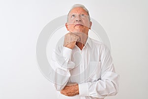 Senior grey-haired man wearing elegant shirt standing over isolated white background with hand on chin thinking about question,