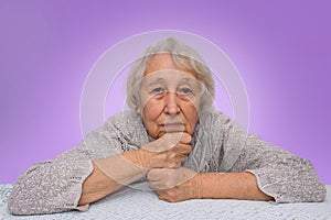 Senior grey haired woman dreaming isolated on blue background