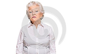 Senior grey-haired woman wearing casual clothes relaxed with serious expression on face