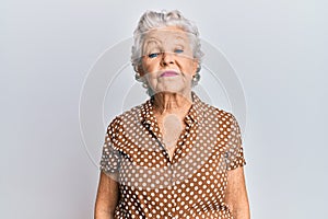Senior grey-haired woman wearing casual clothes relaxed with serious expression on face