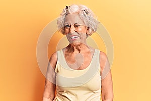 Senior grey-haired woman wearing casual clothes winking looking at the camera with sexy expression, cheerful and happy face