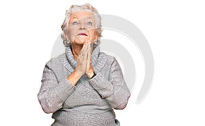 Senior grey-haired woman wearing casual winter sweater begging and praying with hands together with hope expression on face very