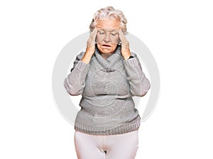 Senior grey-haired woman wearing casual winter sweater with hand on head, headache because stress