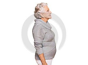 Senior grey-haired woman wearing casual winter sweater looking to side, relax profile pose with natural face and confident smile