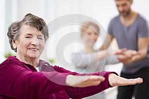 Senior grey woman exercising at hospital physiotherapy center