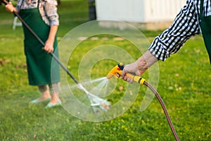 Senior hand holding water hose.