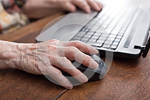 Senior hand using the mouse of a computer