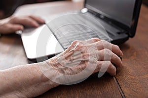 Senior hand using the mouse of a computer