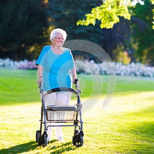 Senior handicapped lady with a walker in a park